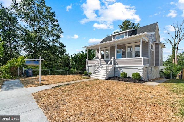 2704 Rueckert Ave, Baltimore, MD 21214 - view of front of house featuring a porch, a shingled roof, fence, and stairs