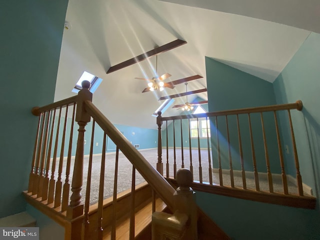 stairway with a ceiling fan, vaulted ceiling, and wood finished floors
