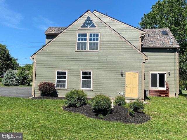 back of property with a yard and entry steps
