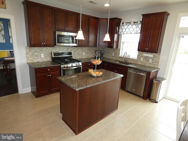 kitchen with appliances with stainless steel finishes, a sink, backsplash, and light tile patterned floors