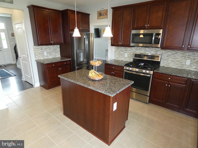 kitchen featuring stainless steel appliances, tasteful backsplash, dark stone counters, and light tile patterned floors