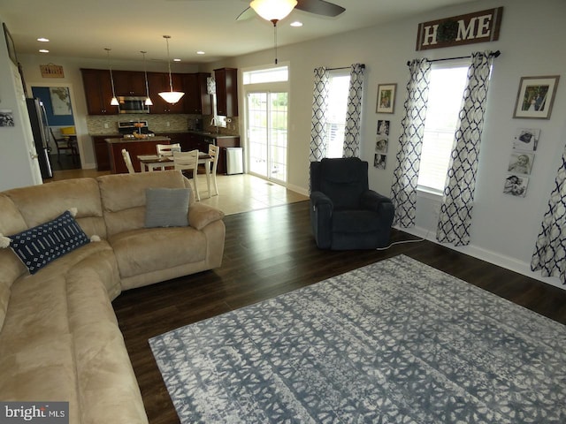 living area featuring dark wood-style floors, a ceiling fan, baseboards, and recessed lighting