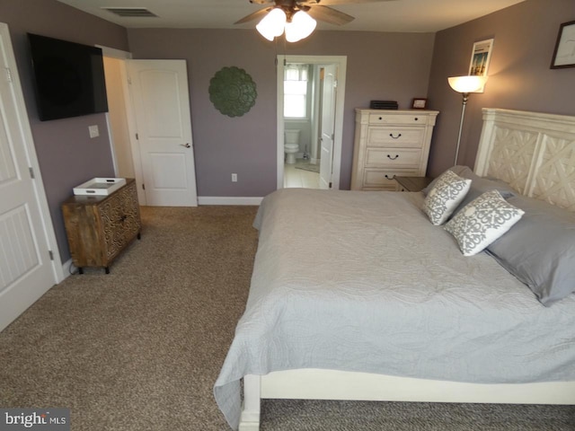 bedroom featuring light colored carpet, baseboards, ensuite bathroom, and a ceiling fan