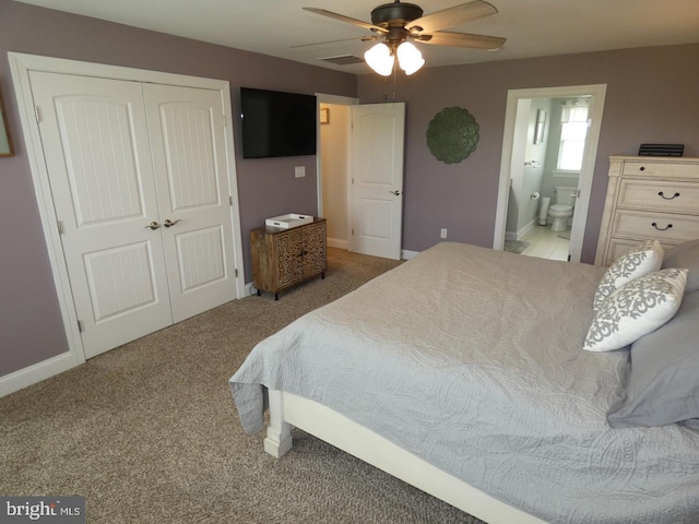carpeted bedroom with a closet, ensuite bathroom, baseboards, and a ceiling fan