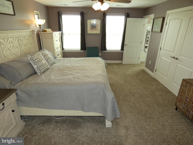 carpeted bedroom with multiple windows, ceiling fan, and baseboards