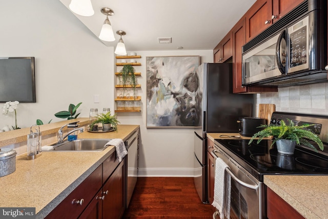 kitchen featuring appliances with stainless steel finishes, decorative backsplash, baseboards, dark wood-style flooring, and light countertops