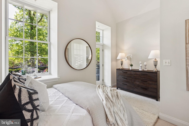 carpeted bedroom featuring baseboards and vaulted ceiling