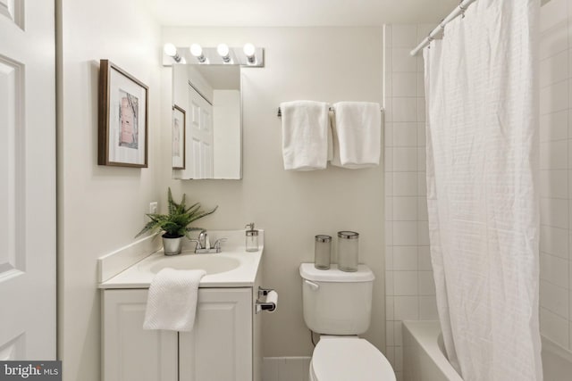 bathroom with toilet, vanity, and shower / bath combo
