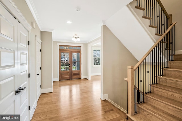 entryway featuring light wood-style floors, baseboards, crown molding, stairs, and recessed lighting