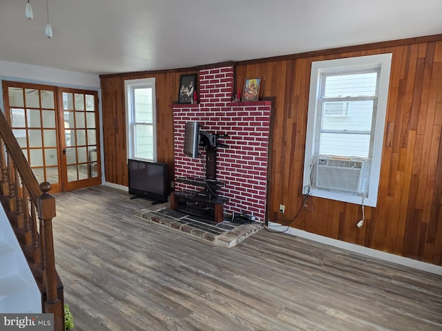 4527 Main St, Whitehall, PA 18052 - unfurnished living room featuring wood finished floors, cooling unit, a wood stove, healthy amount of natural light, and wooden walls