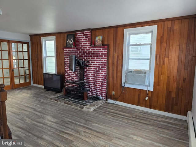 4527 Main St, Whitehall, PA 18052 - unfurnished living room with wood finished floors, cooling unit, a wood stove, wood walls, and a baseboard radiator
