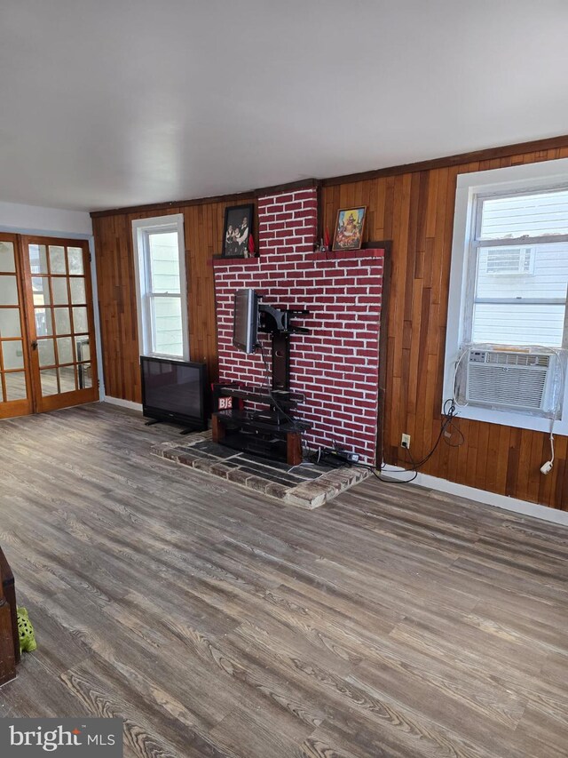 4527 Main St, Whitehall, PA 18052 - unfurnished living room featuring a wood stove, wooden walls, wood finished floors, baseboards, and cooling unit