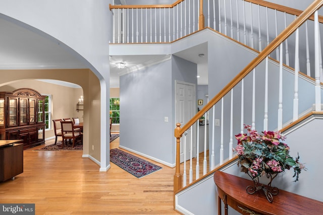 15066 Frederick Rd, Cooksville, MD 21723 - entryway with arched walkways, wood finished floors, stairway, ornamental molding, and a towering ceiling