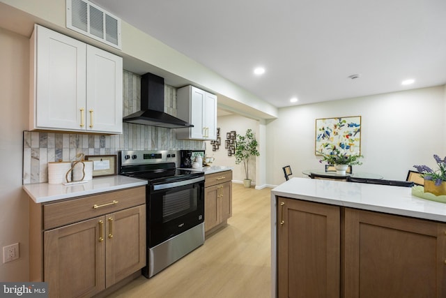 127 Toledo Ln, Willingboro, NJ 08046 - kitchen featuring wall chimney range hood, stainless steel electric range oven, light wood finished floors, white cabinetry, and recessed lighting