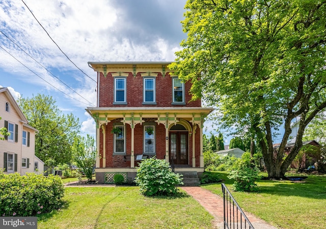 italianate home with brick siding, a porch, and a front yard