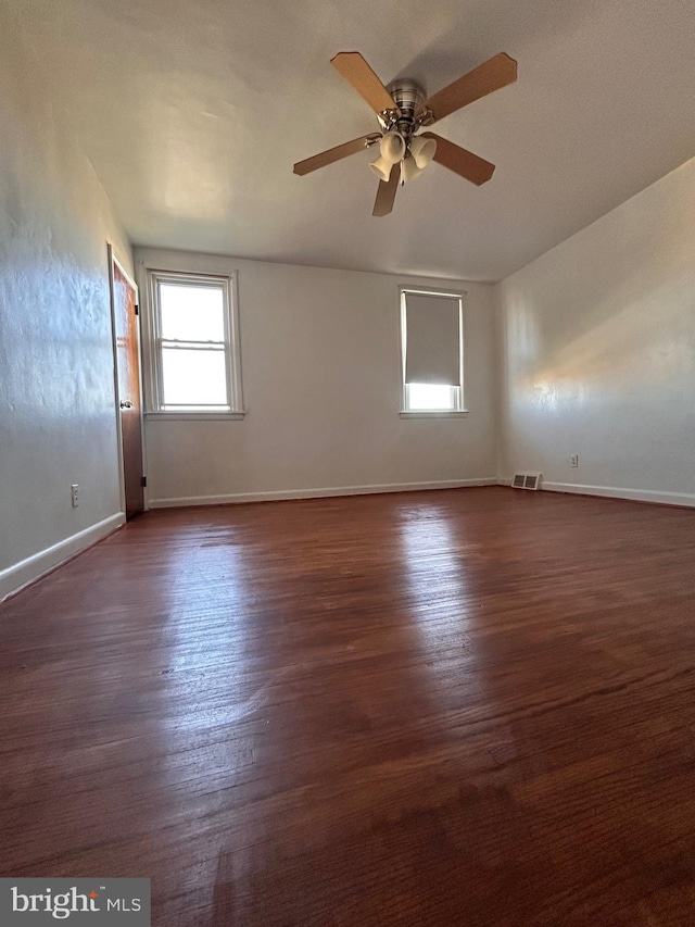 unfurnished room with ceiling fan, baseboards, and dark wood-style flooring