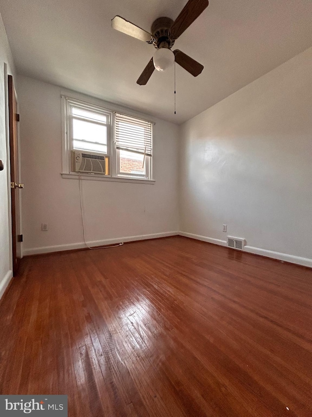 unfurnished room with wood finished floors, cooling unit, baseboards, and ceiling fan