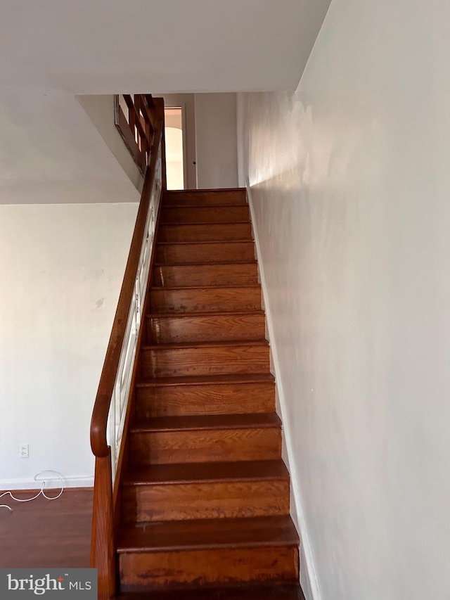 staircase with baseboards and wood finished floors