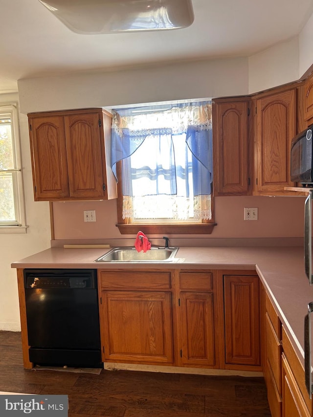 kitchen featuring black appliances, a sink, brown cabinetry, and light countertops