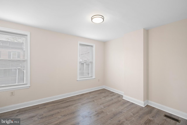 spare room featuring wood finished floors and baseboards