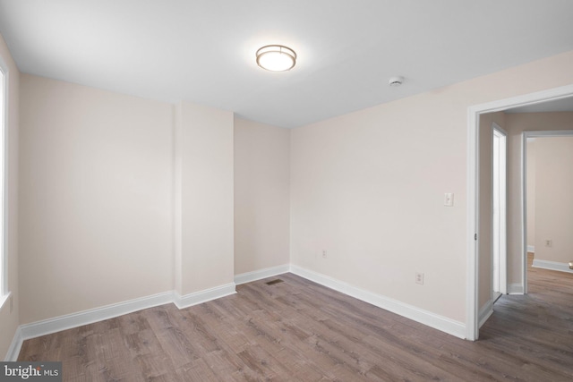 empty room featuring wood finished floors and baseboards