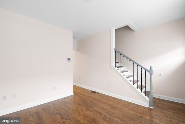staircase featuring wood finished floors and baseboards