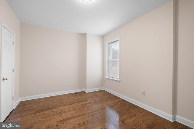 unfurnished bedroom with dark wood-style flooring and baseboards