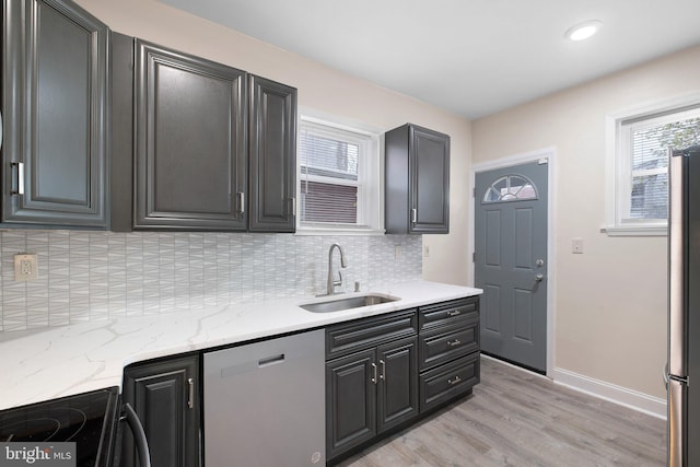 kitchen featuring a sink, stainless steel dishwasher, light wood finished floors, black electric range oven, and plenty of natural light