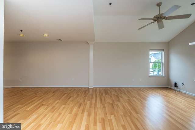 empty room featuring light wood-style floors, a ceiling fan, baseboards, recessed lighting, and ornate columns