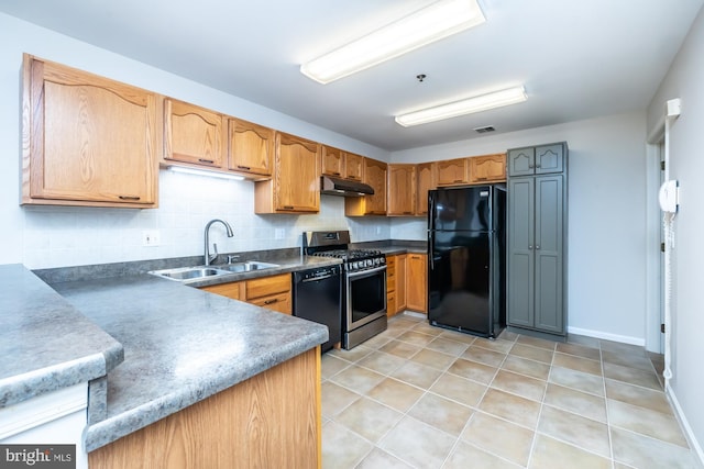 kitchen with black appliances, a sink, under cabinet range hood, tasteful backsplash, and light tile patterned floors
