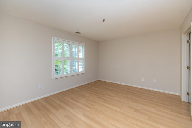empty room featuring light wood-style floors and baseboards