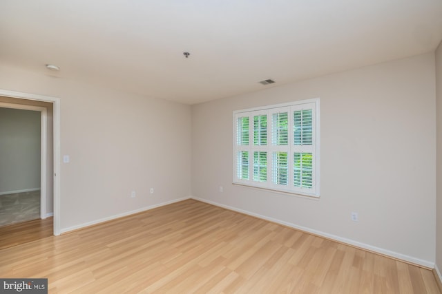 unfurnished room with light wood-style flooring and baseboards