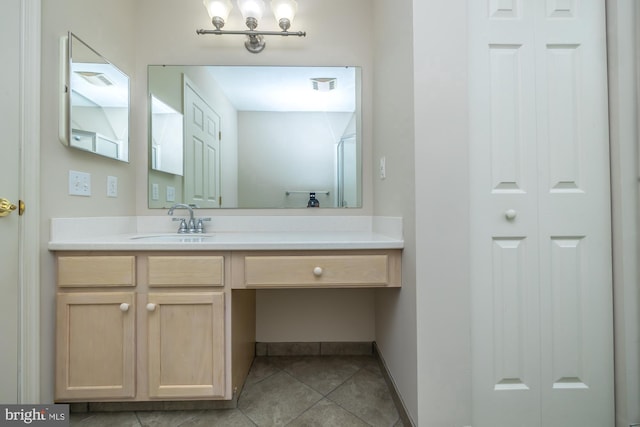 bathroom featuring a closet, vanity, tile patterned floors, and baseboards