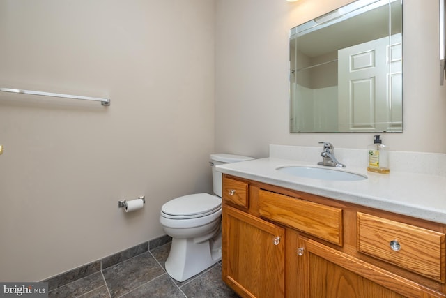 full bath featuring toilet, vanity, and baseboards