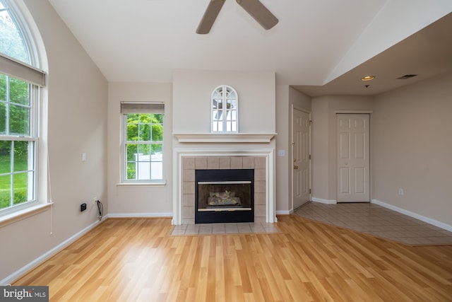 unfurnished living room featuring a ceiling fan, wood finished floors, a fireplace, baseboards, and lofted ceiling