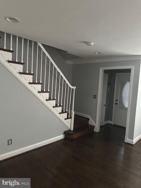 entryway with stairway, ornamental molding, baseboards, and wood finished floors
