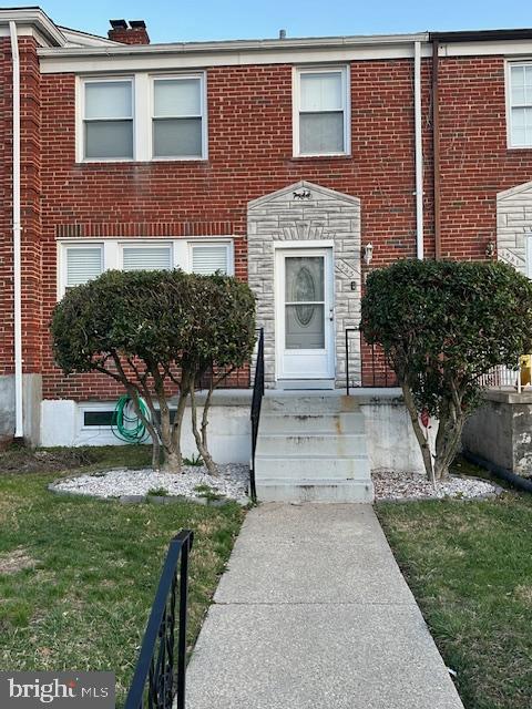 townhome / multi-family property with brick siding and a chimney