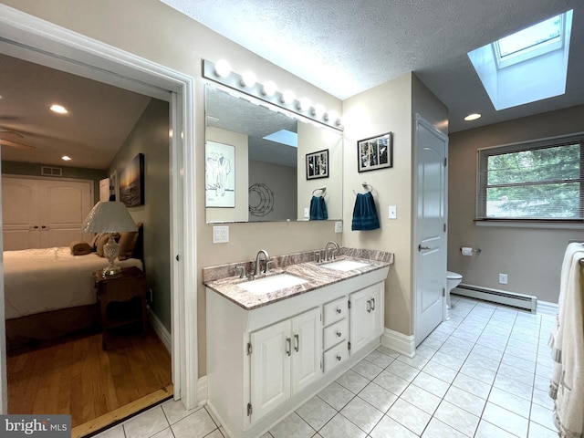 8408 Alvin Rd, Pasadena, MD 21122 - ensuite bathroom featuring a baseboard radiator, a skylight, toilet, baseboards, and tile patterned flooring