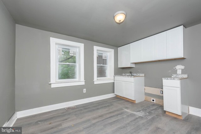 laundry area with light wood-style floors, baseboards, and a sink