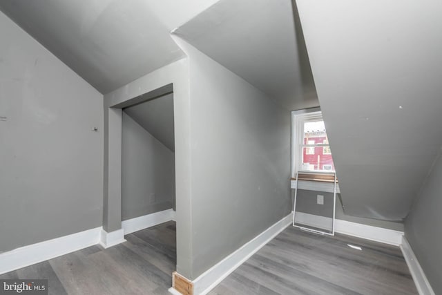 bonus room featuring wood finished floors, baseboards, and vaulted ceiling