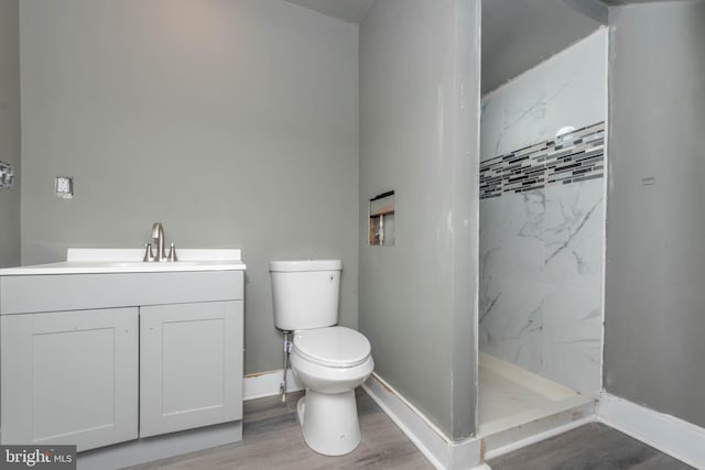 full bath featuring toilet, a shower stall, wood finished floors, vanity, and baseboards