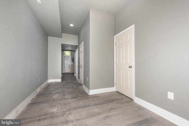 hallway with wood finished floors, baseboards, and recessed lighting