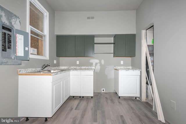 kitchen with a sink, light wood-style floors, and light countertops