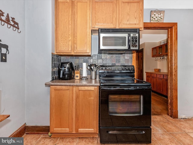 6103 Jefferson Pike, Frederick, MD 21703 - kitchen with stainless steel microwave, black electric range, baseboards, backsplash, and light tile patterned floors