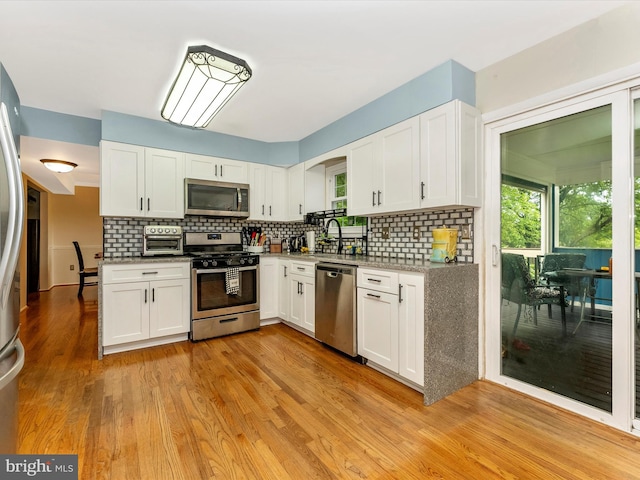 24129 Pecan Grove Ln, Gaithersburg, MD 20882 - kitchen featuring appliances with stainless steel finishes, white cabinets, backsplash, and a sink
