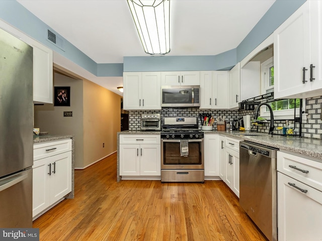 24129 Pecan Grove Ln, Gaithersburg, MD 20882 - kitchen with stainless steel appliances, a sink, tasteful backsplash, and white cabinetry
