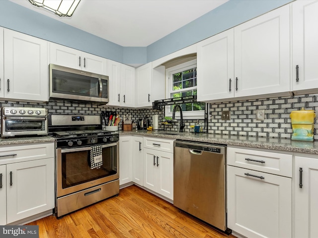 24129 Pecan Grove Ln, Gaithersburg, MD 20882 - kitchen featuring stainless steel appliances, a sink, white cabinets, backsplash, and light wood-type flooring