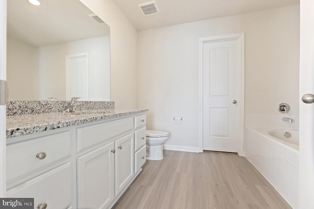 24 Cramsford St, Falling Waters, WV 25419 - full bathroom featuring wood finished floors, toilet, vanity, a relaxing tiled tub, and baseboards