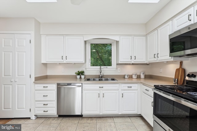 kitchen featuring appliances with stainless steel finishes, a sink, white cabinetry, and light countertops