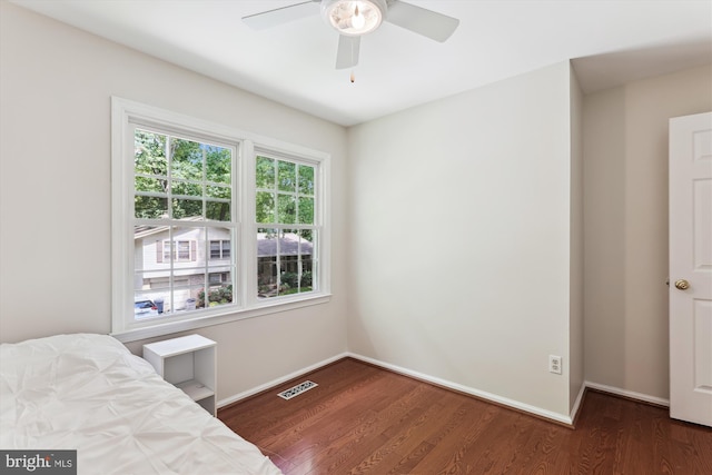 bedroom with wood finished floors, baseboards, and a ceiling fan